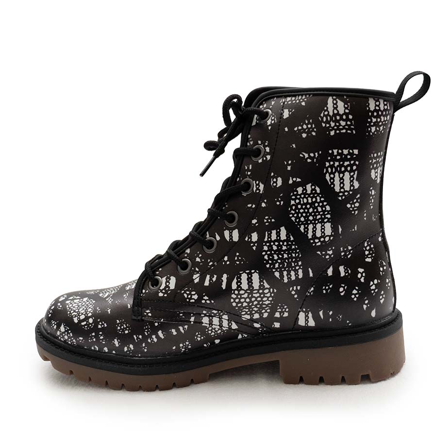 Inside of right boot of black lace-up boots with black and white lace pattern on a white background