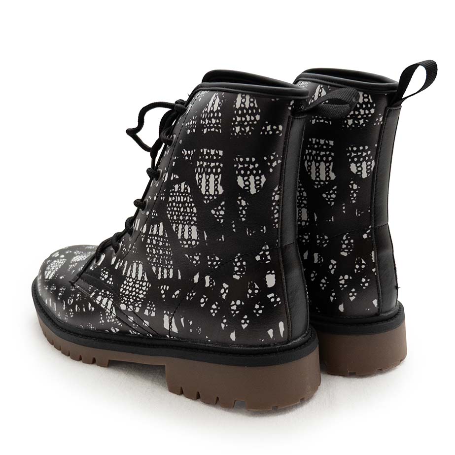 Angled back view of black lace-up boots with black and white lace pattern on a white background
