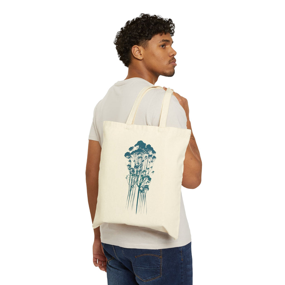 Eco-Friendly Cotton Canvas Tote Bag with Delicate Trees Drawing in Natural held over a shoulder of a man.