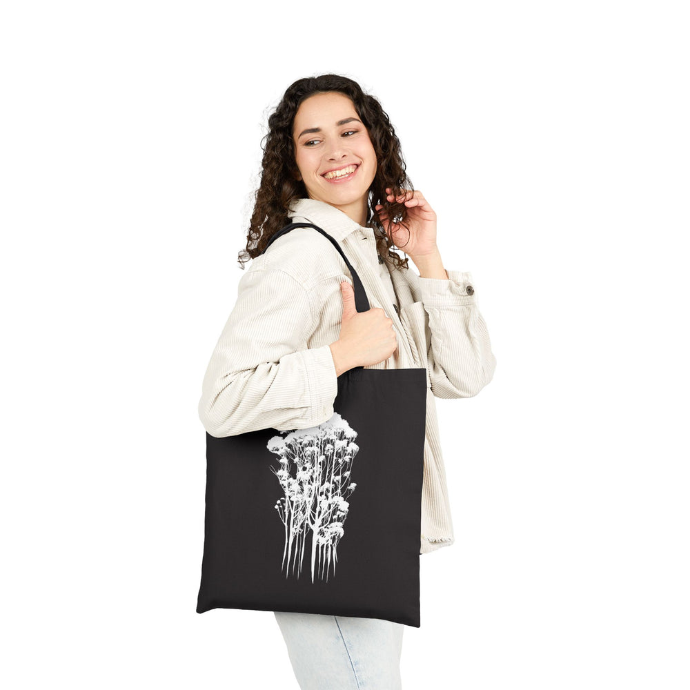 Eco-Friendly Cotton Canvas Tote Bag with Delicate Trees Drawing in black held at side over shoulder