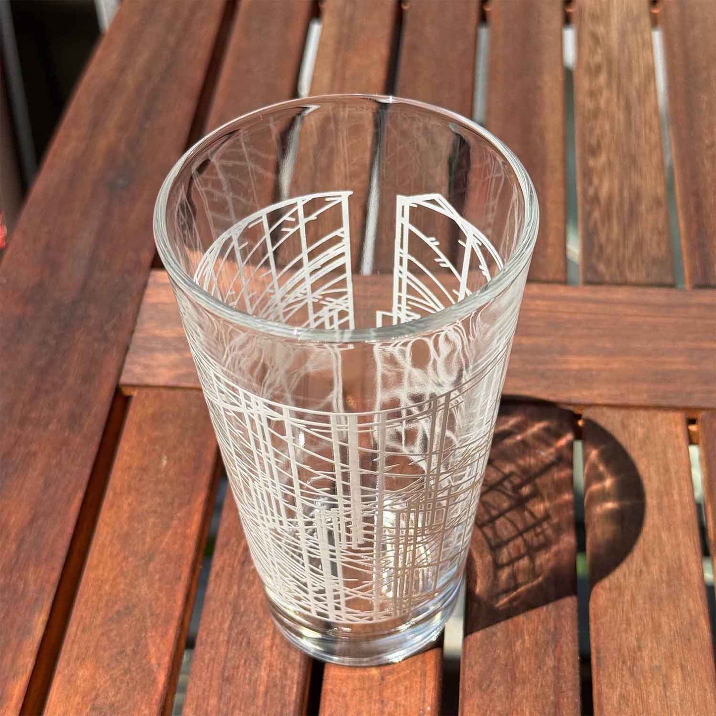 Clear glass with white geometric design on a wooden surface