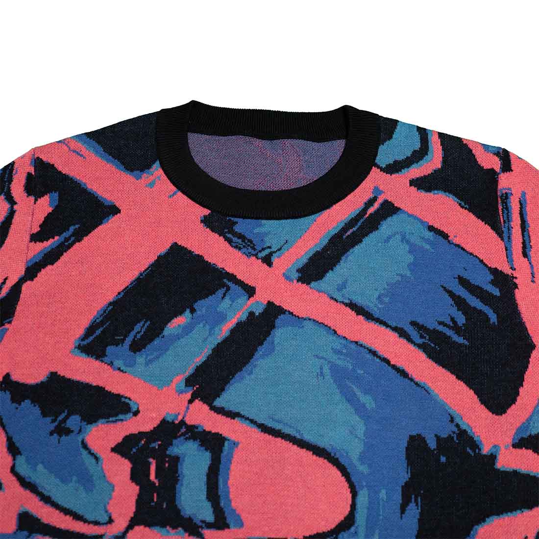 Collar and shoulders of knitted sweater with abstract design in pink, blue, and black on a white background