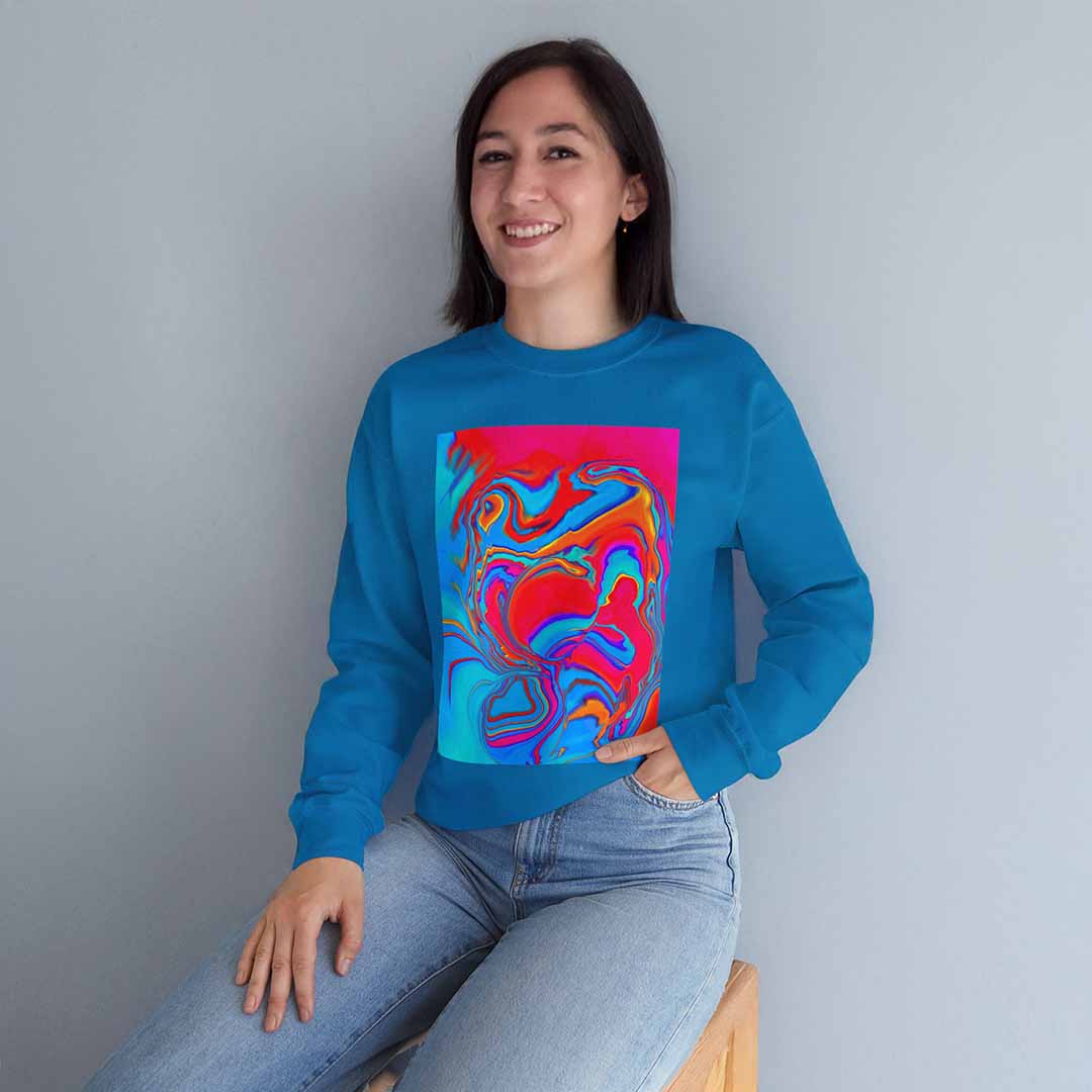 Person wearing a sapphire blue sweatshirt with a colorful abstract design against a plain background