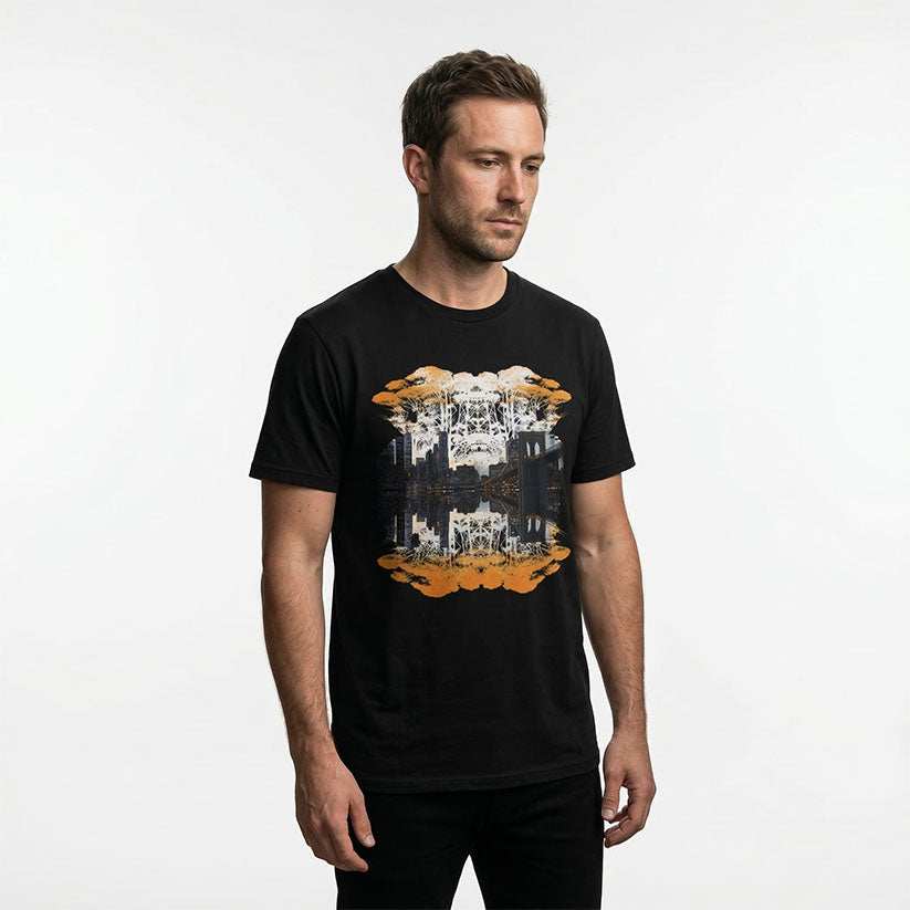 Man wearing graphic print of trees and NYC skyline on a black t-shirt on a white background