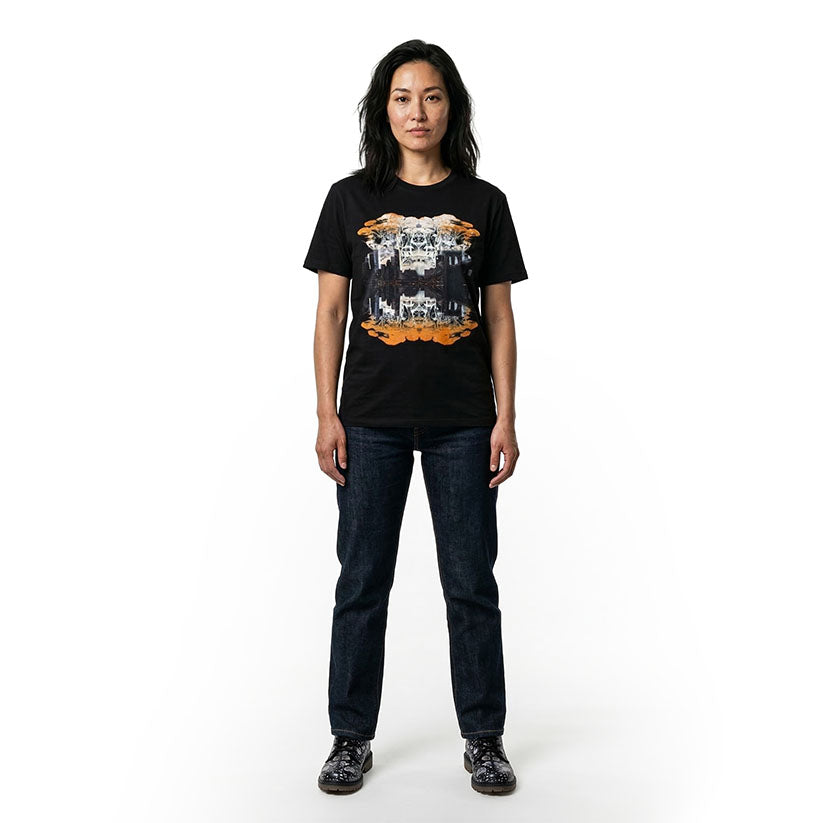 Woman wearing black graphic t-shirt with a print of trees and NYC skyline on a white background
