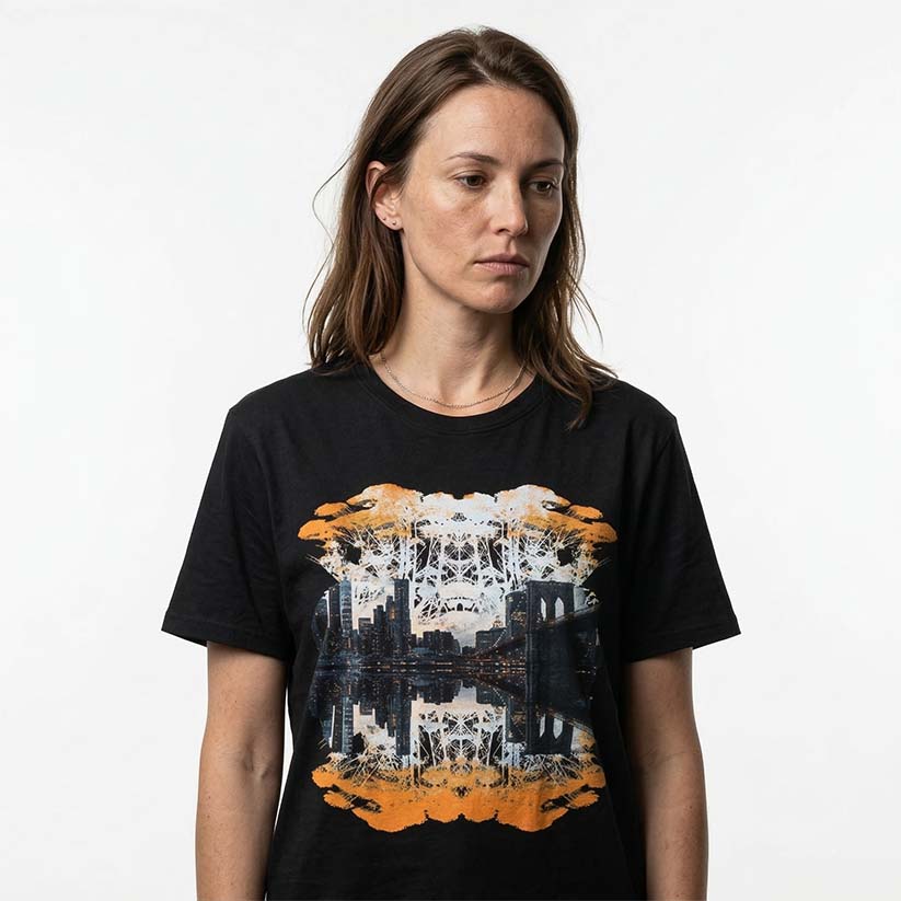 Woman wearing graphic print of trees and NYC skyline on a black t-shirt on a white background