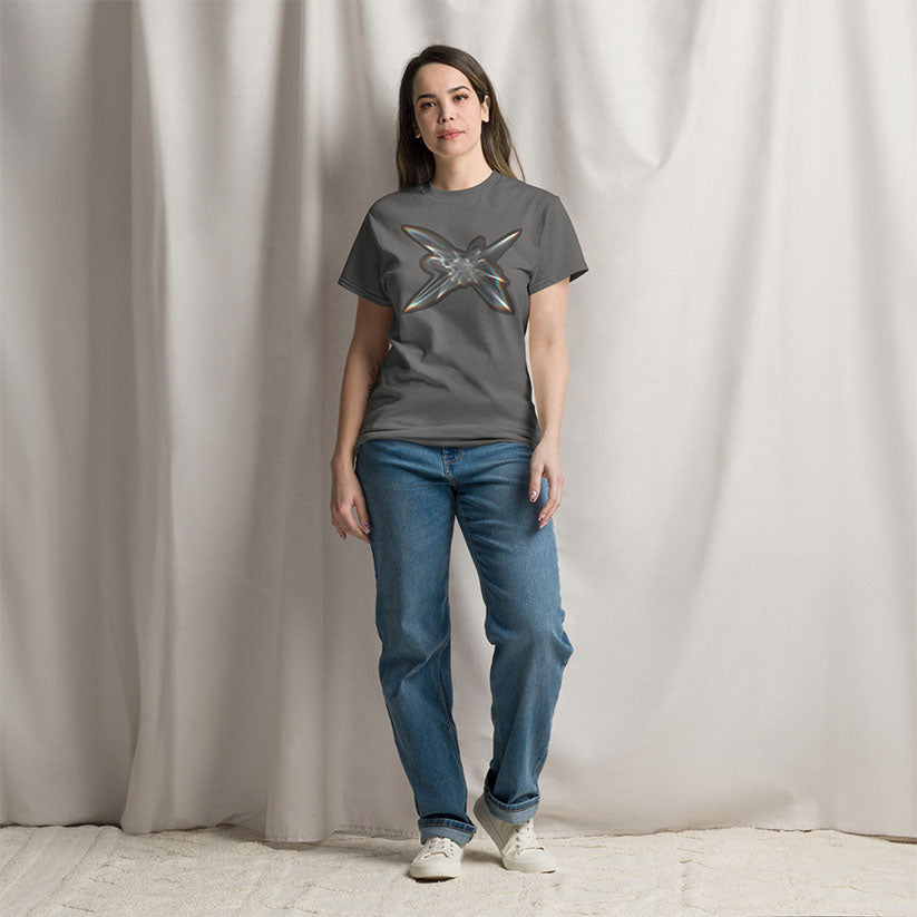 Woman wearing The Light Within graphic t-shirt in charcoal gray standing in front of a neutral curtain.
