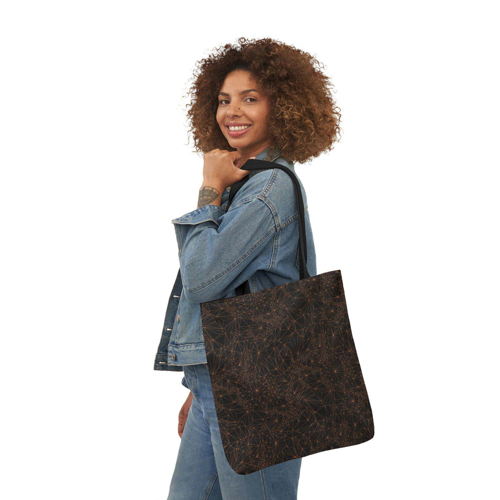 A woman holding the 18x18 inch version of the dark Tri-Mesh Geometric tote bag featuring a black inner lining and black handle.