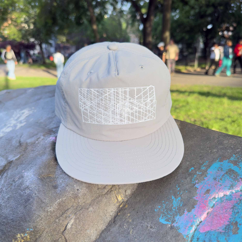 Storm gray Eco-Conscious Recycled Nylon Surf Cap Hat with white Digi Board Lines sitting on a rock with grafitti.